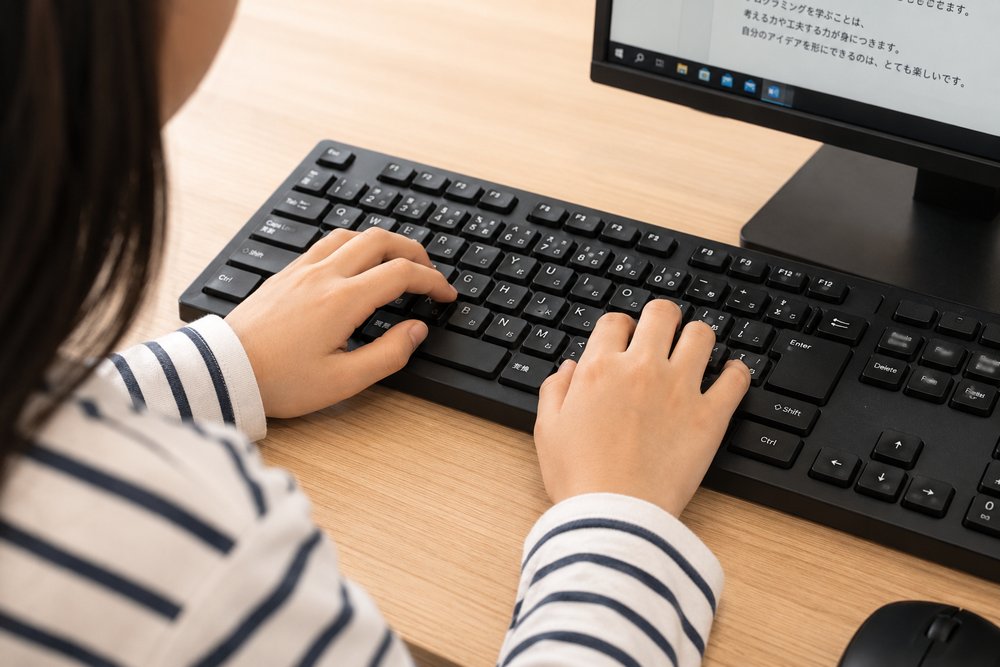 キーボードを打ちながらパソコンに向かう子ども